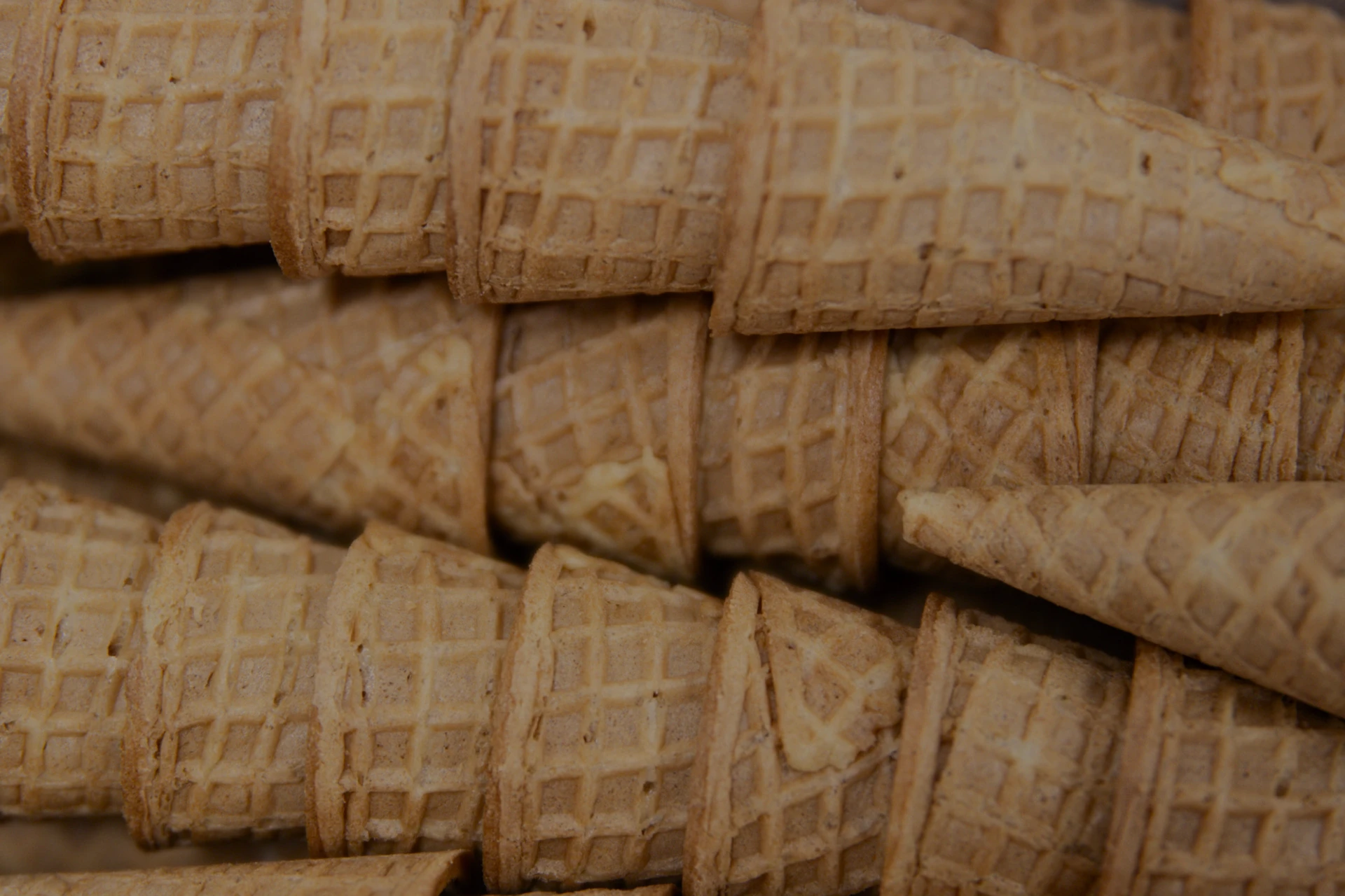 Imagen de tres filas de cucuruchos de helado artesanales recién horneados